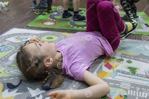 A Little Tired Girl Is Lying On The Floor In The Nursery Editorial