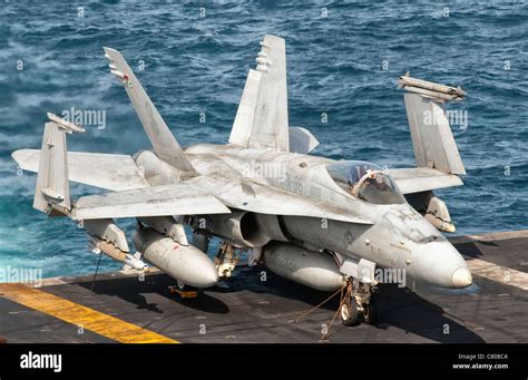 A Us Navy F A 18C Hornet Tied Down On The Flight Deck Of Aircraft