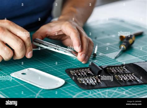 Electronics Repair Service Technician Disassembling Smartphone For