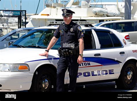 Police Officer Standing Next To Police Car